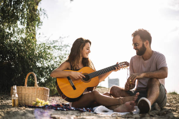 istock Couple on the river playing the guitar 1036006436