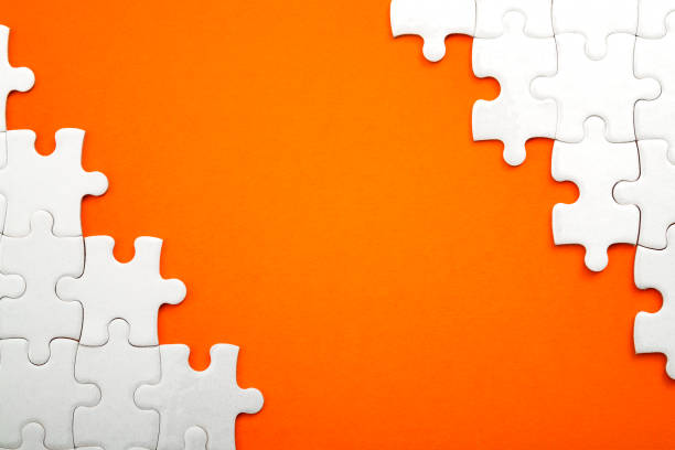 istock Jigsaw puzzle frame orange background with copyspace in the middle 1036013212