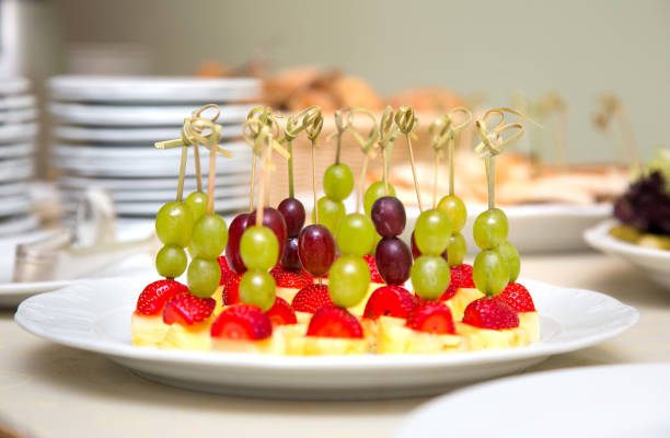 Fruit canape. Portional canapes from grapes, strawberries and pineapple