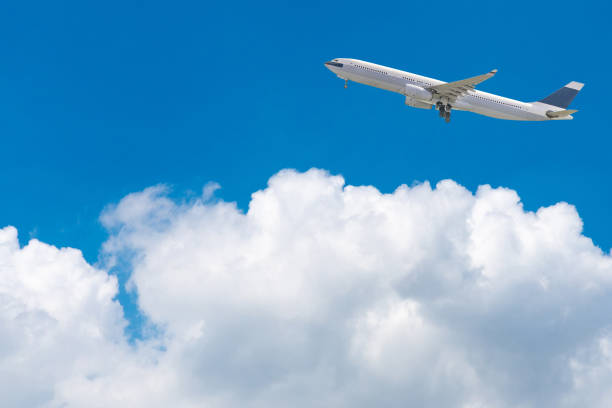istock Commercial airplane flying over bright blue sky and white clouds 1036018642