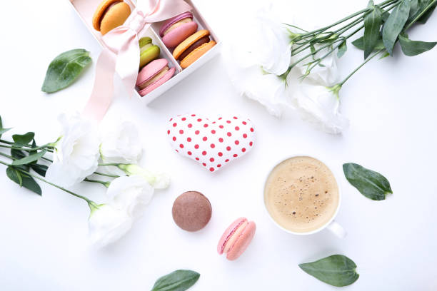 istock Sweet macaroons with eustoma flowers and cup of coffee on white background 1036020436