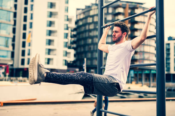istock Healthy young man exercising on wall bars during sunset 1036023130