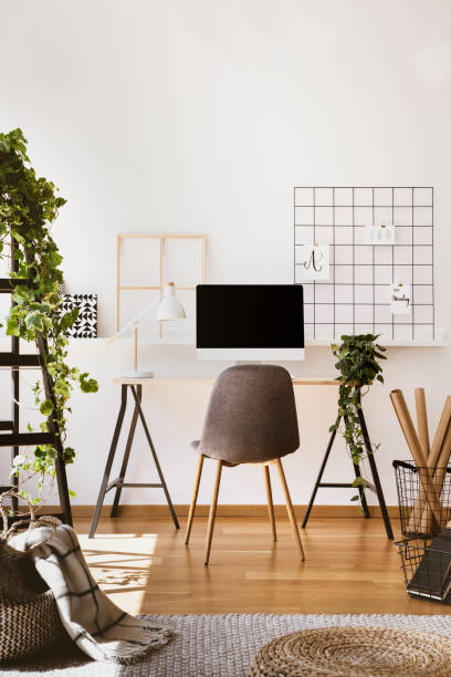 istock Plant, white lamp and desktop computer on desk in freelancer's interior with grey chair. Real photo 1036026834