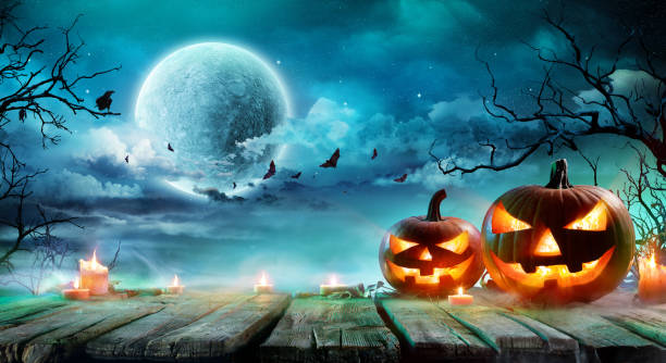 istock Halloween - Jack O' Lanterns And Candles On Table In Misty Night 1036034774