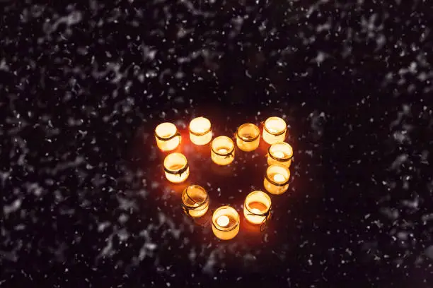 Photo of Candlesticks with burning candles in the form of a heart