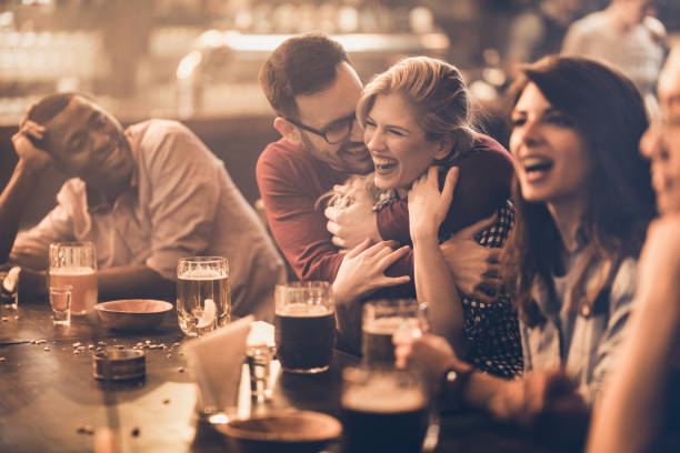 istock Happy affectionate couple having fun with their friends in a pub. 1036036294