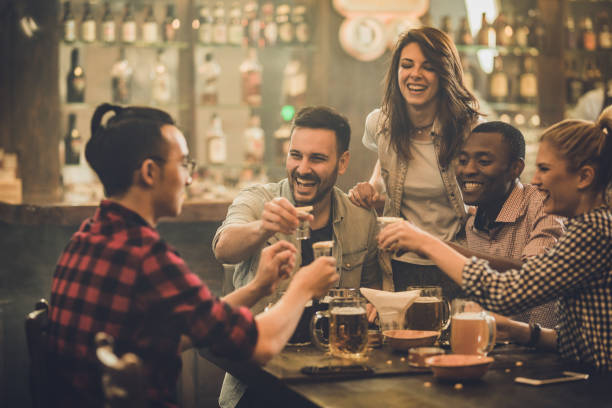 istock Cheerful friends having fun while toasting with shots during their night out in a bar. 1036041454
