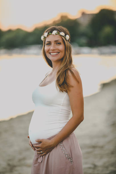 istock Young pregnant woman standing by the river 1036041504