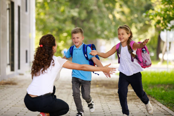 istock Excited mom waits for her children after school 1036044344