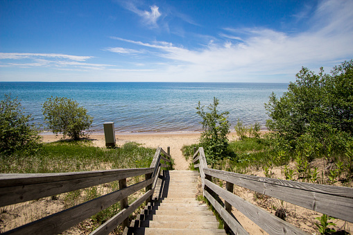 Waterfront park with a wide sandy beach on the shores of Lake Michigan in the downtown district of the Upper Peninsula city of Manistique Michigan.