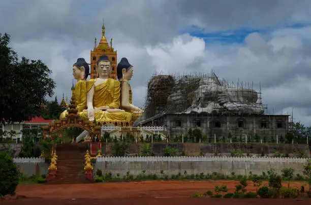 Large, golden, sitting Buddha statues and an unfinished reclining Buddha in Ye, Myanmar