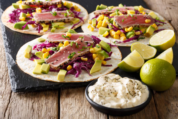 istock Fish takos with fried tuna, corn, red cabbage, lime and avocado close-up. horizontal 1036052624
