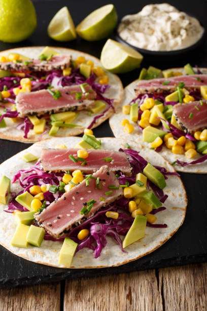 istock tortilla with tuna steak, sesame and fresh vegetables close-up. vertical 1036052936