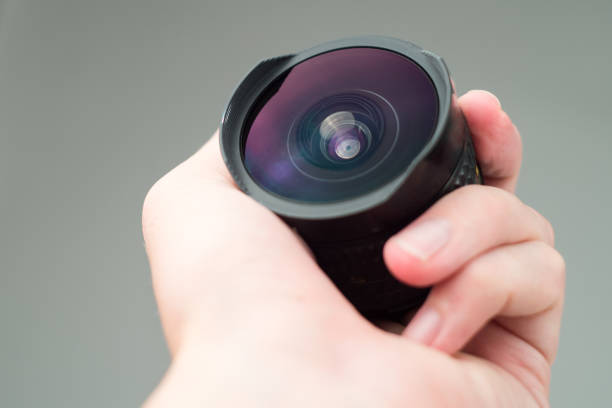 istock Old lens in hands on a white background 1036067194