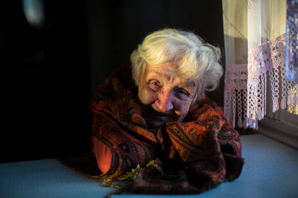портрет пожилой дамы, сидящей в темноте в доме. - 15832 стоковые фото и изображения