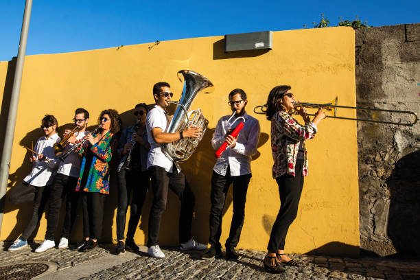 banda de jazz, un grupo de músicos tocar en la calle cerca de la pared amarilla. - brass instrument jazz brass trumpet fotografías e imágenes de stock