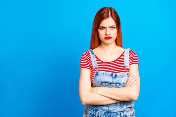 istock Red straight-haired vivid young girl with folded hands, wearing 1036076158