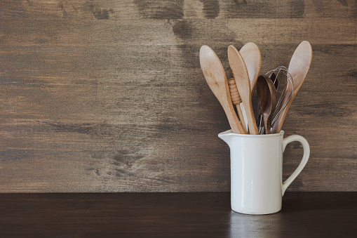 Crockery, clayware, dark utensils and other different stuff on wooden table-top. Kitchen still life as background for design. Copy space.