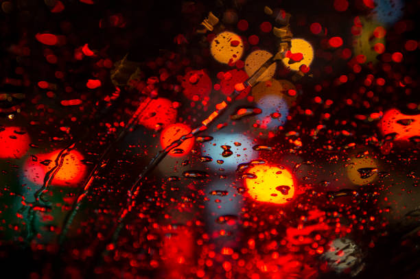 Close up of raindrops on windshield at night in the city\