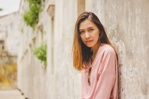 istock The woman leaning against the old cement wall. 1036085420