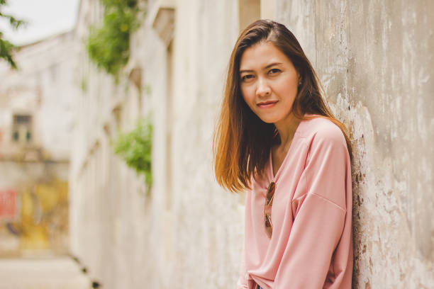 istock The woman leaning against the old cement wall. 1036085446