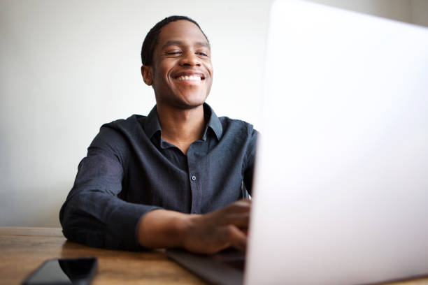 istock happy young businessman sitting at desk with laptop computer 1036091700