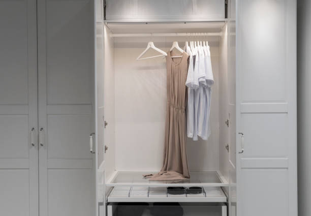 istock White t-shirts on hangers in wardrobe 1036097526
