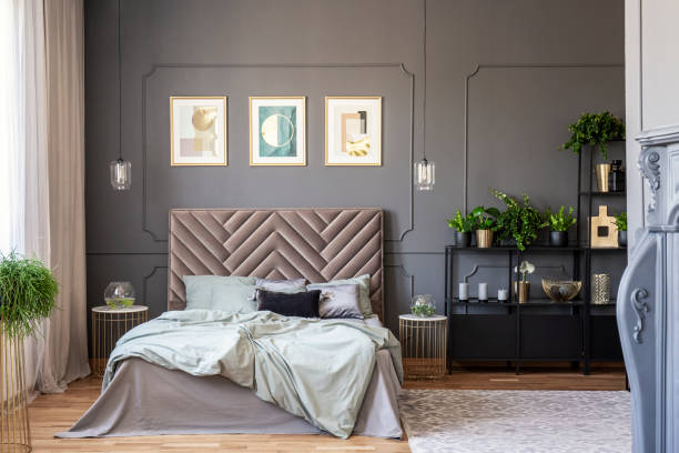 istock Dark bedroom interior with a comfy double bed, paintings and black shelf and wall molding 1036097642