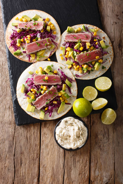 istock Tacos with tuna steak and fresh vegetables close-up. Vertical top view 1036110564