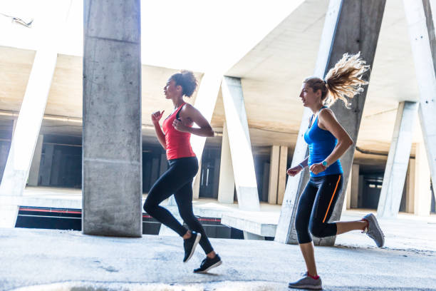 istock Two female athletes running together 1036112340