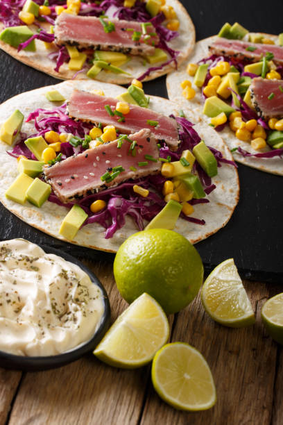 istock tortilla with tuna, sesame, corn, cabbage and avocado close-up. vertical 1036113544