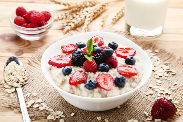 istock Oatmeal with berries in bowl on wooden table 1036119752