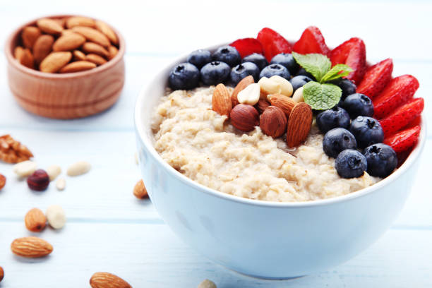 istock Oatmeal with berries and nuts in bowl on wooden table 1036120010