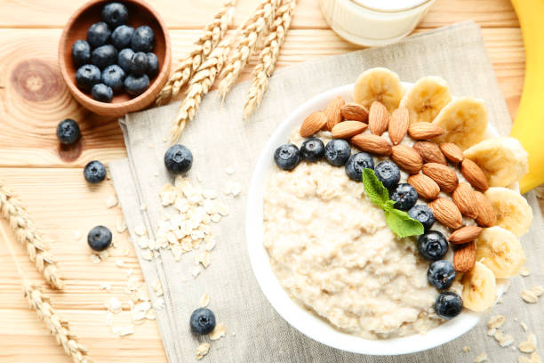 istock Oatmeal with berries and nuts in bowl on wooden table 1036120642