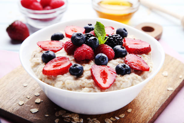 istock Oatmeal with berries in bowl on cutting board 1036120874