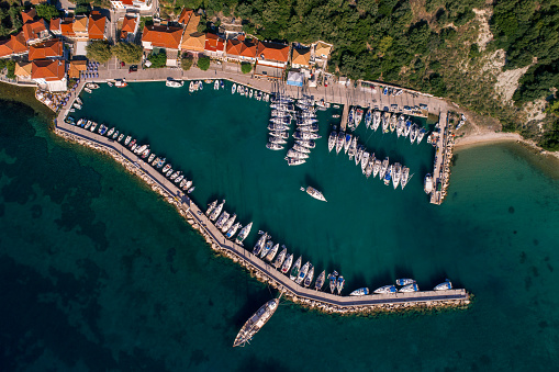 Aerial view of beautiful small village and port on island of Kalamos on Ionian sea. Port is full with sailboats and yachts which is usual for summer.