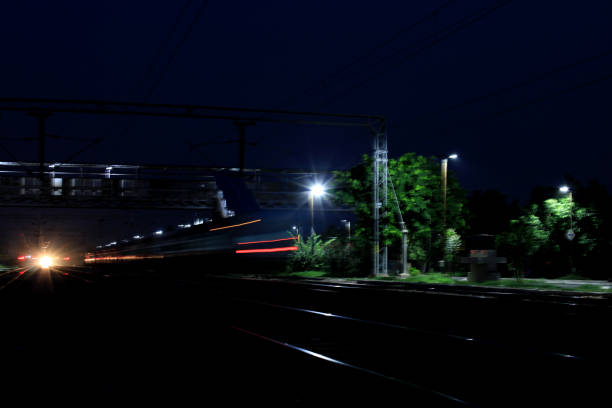 istock Train passing though railroad station at night 1036141156