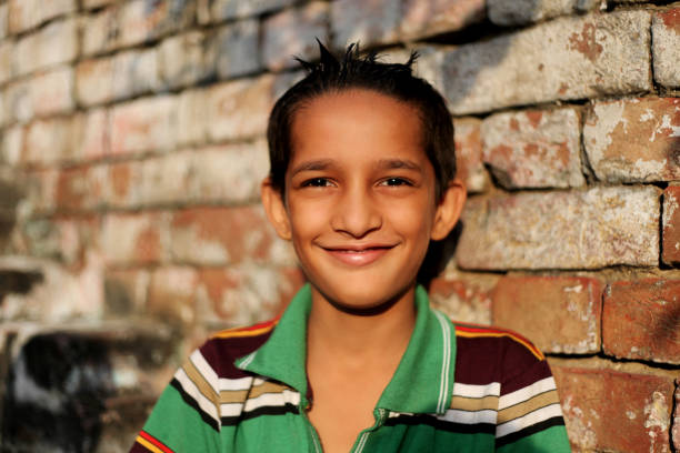 Elementary age child portrait against brick wall at home.