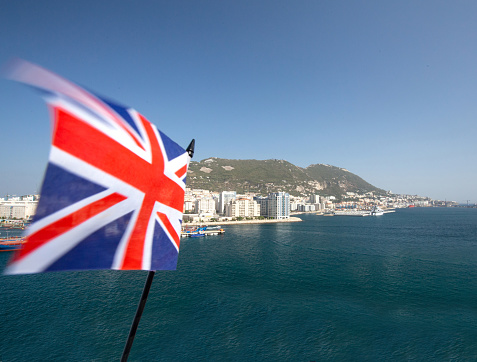 The Union Jack with Gibraltar in the background, indicating the dispute over its sovereignty and the effects of Brexit