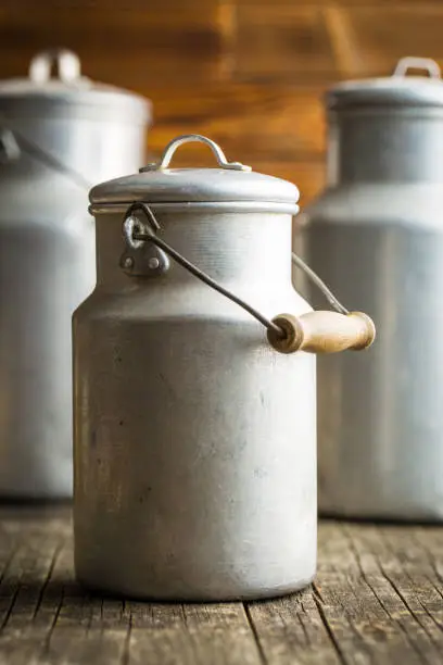 Aluminium milk can on old wooden table.