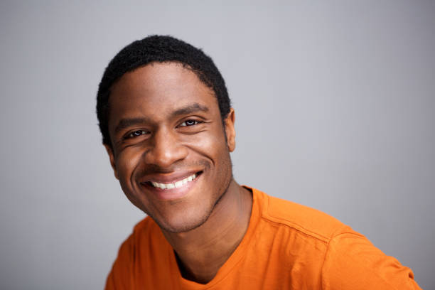 istock Close up young black man smiling against gray background 1036189924