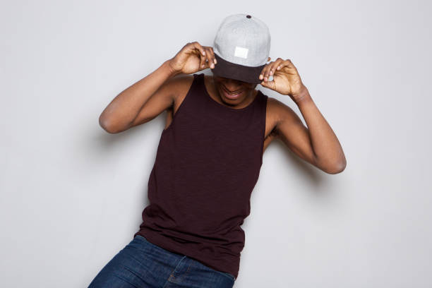 istock happy african american guy holding cap and looking down 1036189990