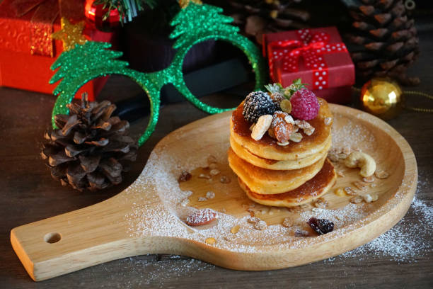 istock Pancake topping with berries and nut with background gift and pine cone under christmas tree, holiday party dessert 1036201518