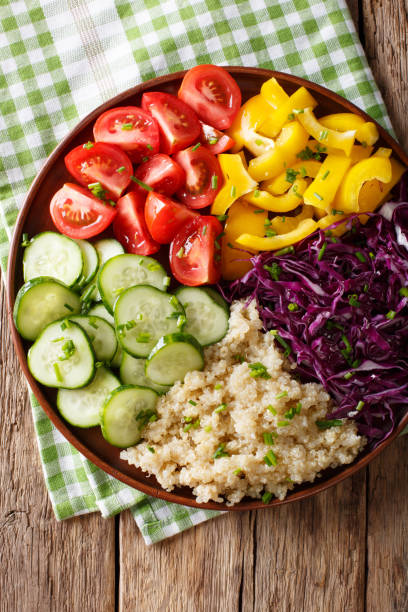 istock salad from quinoa with red cabbage, tomatoes, pepper and cucumbers close-up. Vertical top view 1036201552