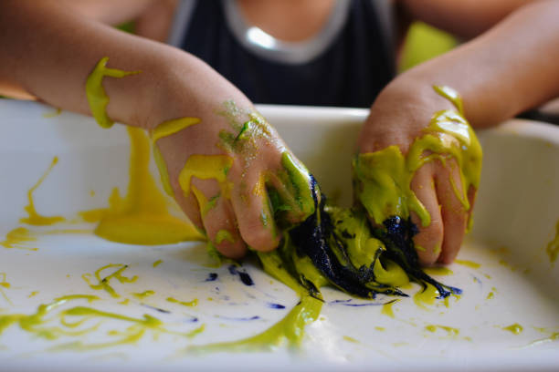 istock CLOSE UP OF CHILD'S HANDS PLAYING WITH HANDMADE GALACTIC SLIME 1036207818