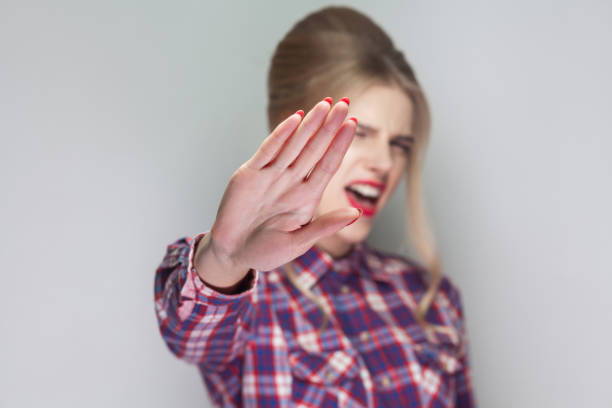 pare. garota com raiva na camisa quadriculada rosa, coletados updo penteado e maquiagem olhando para a câmera com rejeição de proibição ou paragem de aviso e gritando - shirt problems red pink - fotografias e filmes do acervo