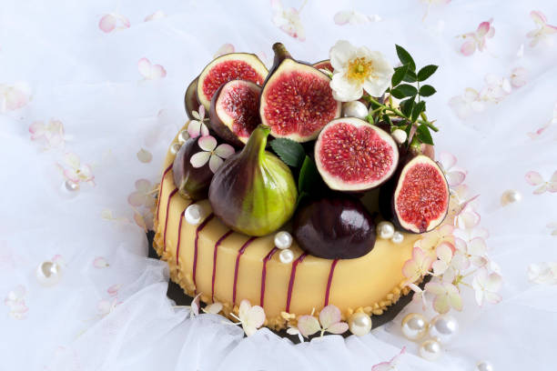 cake with fresh figs cake with fresh figs in wedding decoration with white tulle and pearls white wedding cake red roses stock pictures, royalty-free photos & images