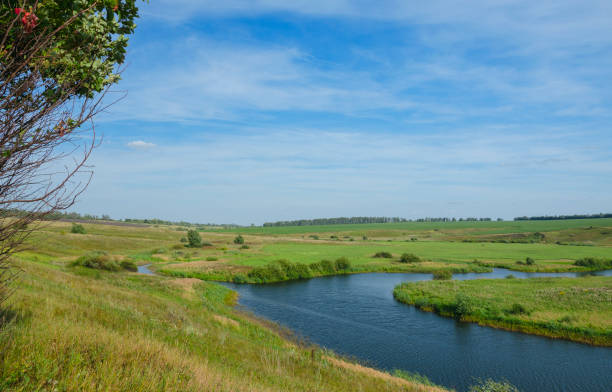 istock Sunny summer landscape with river curve and meadows. 1036224852
