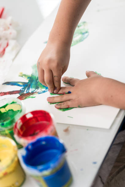 istock Young child doing finger art with colorful paints 1036228214