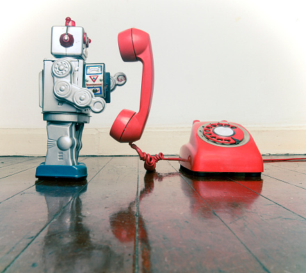 big silver robot toy on  a red phone standing